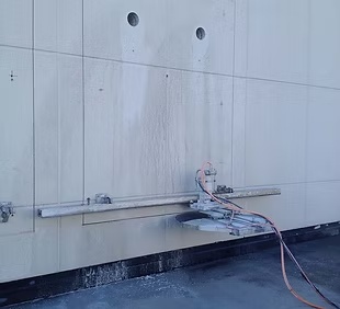 Skinnegående betongsag i arbeid på en betongvegg